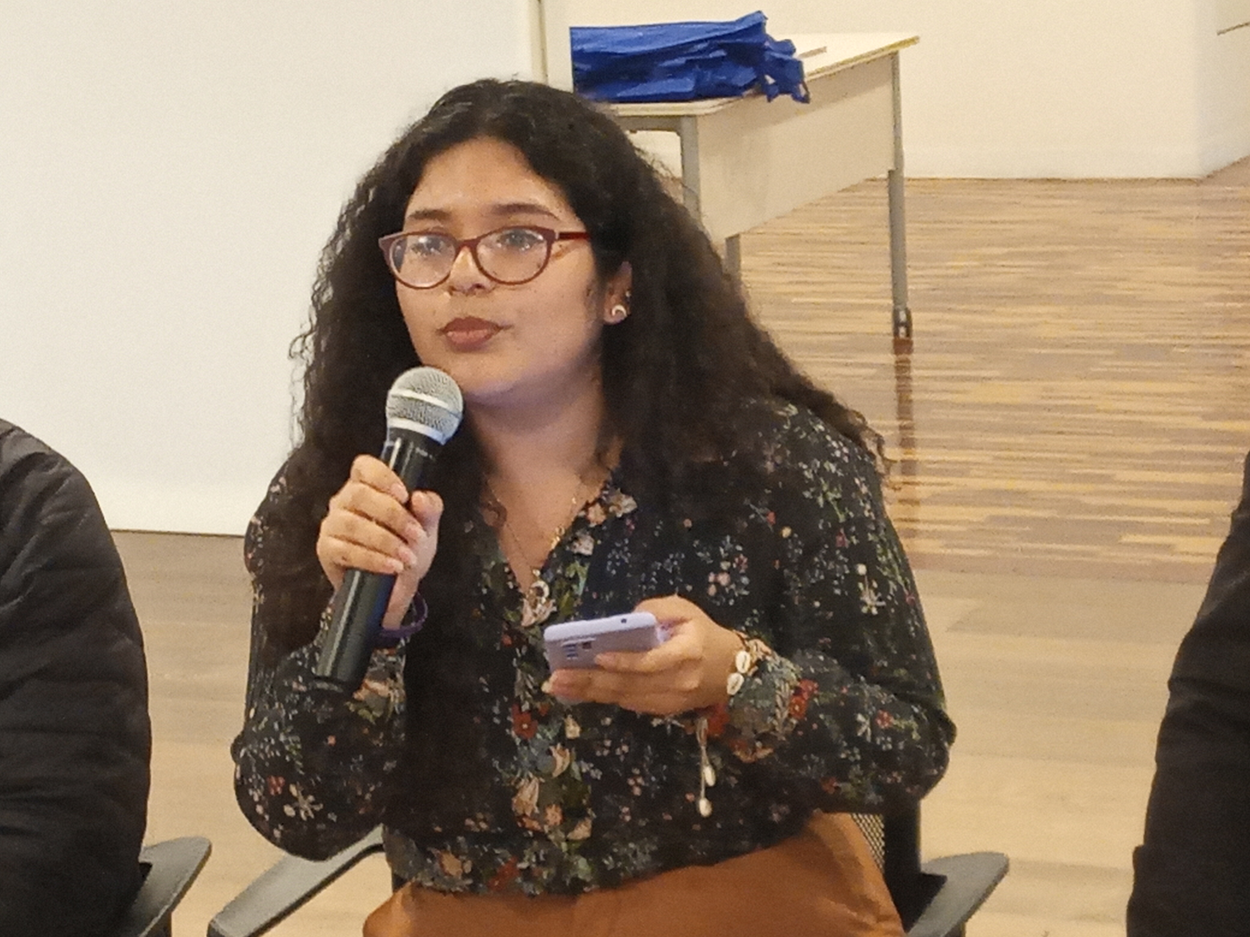 Astry Chavez analizando datos y estudios de la OIM sobre migración y cambio climático durante un taller técnico en Lima.